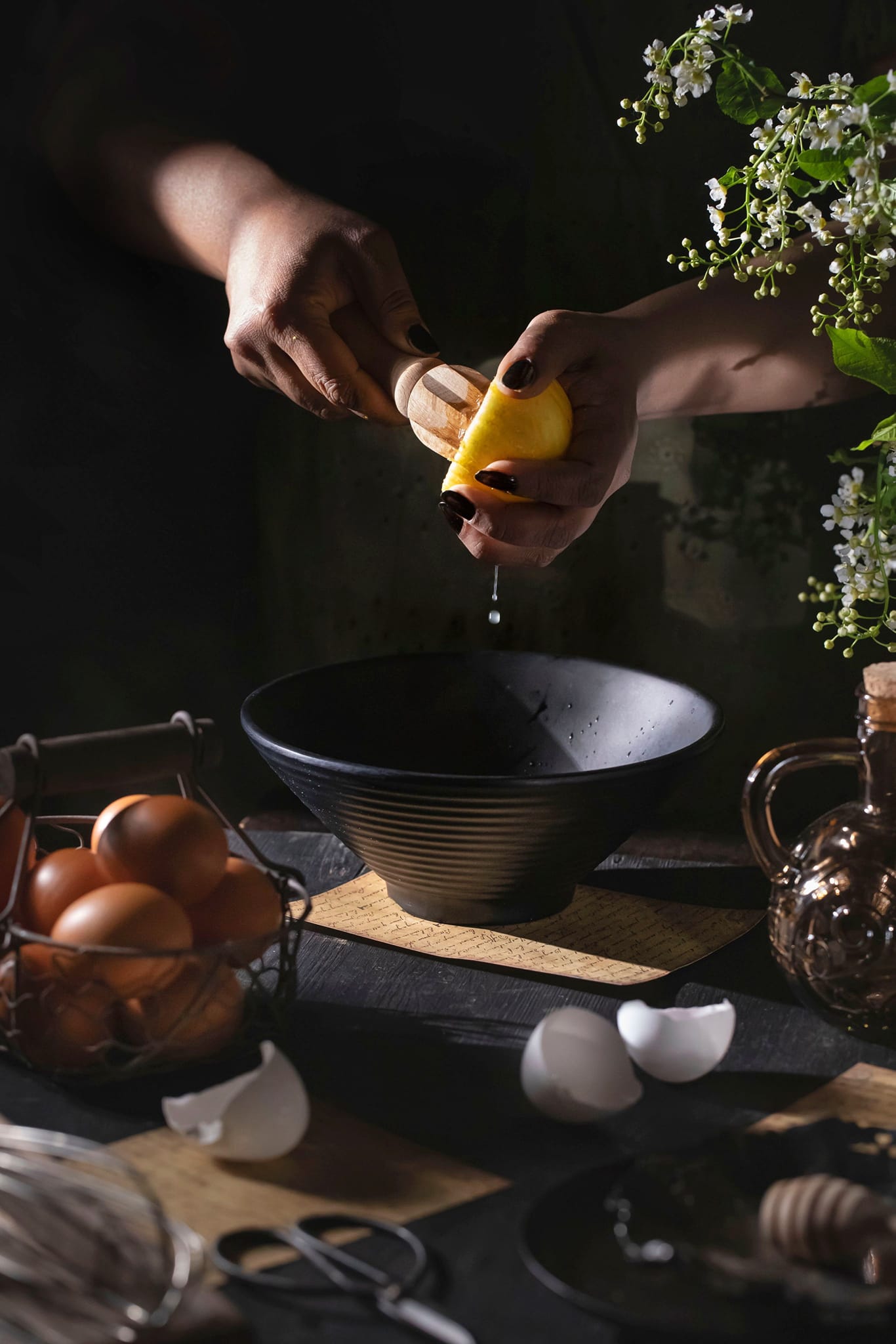 A woman squeezing lemon into a bowl